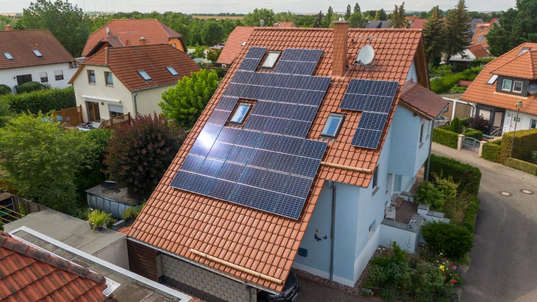 Ein Haus mit Steildach mit Solarmodulen aus der Vogelperspektive