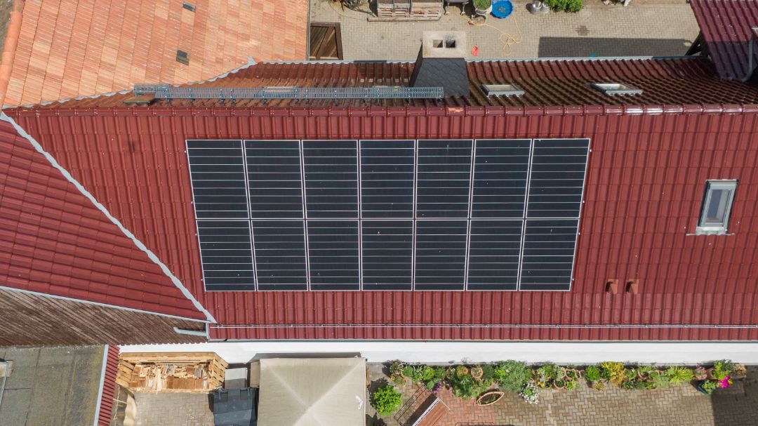 Ein Haus mit Solarmodulen aus der Vogelperspektive