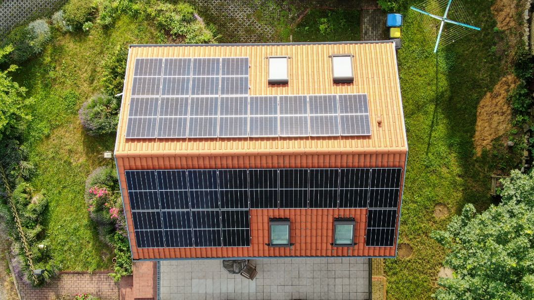 Ein Haus mit Solarmodulen aus der Vogelperspektive